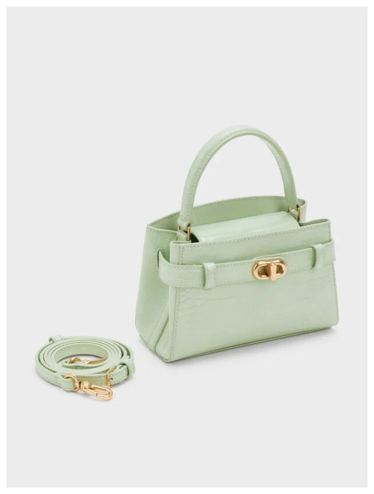 Angled side view of Charles & Keith Aubrielle mint croc-effect top handle bag with detachable strap.