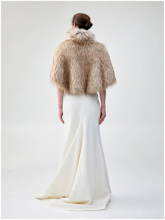 Back view of Unreal Fur Nord Cape in natural showing the cropped cape silhouette, high collar and long-pile faux fur texture.