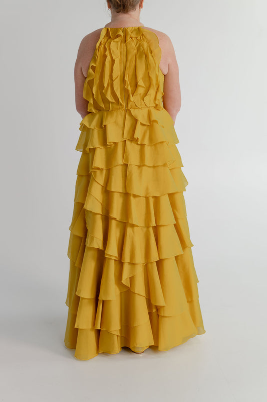 Back view of the Aje Cleo golden chartreuse formal gown showing cascading ruffles, fitted bodice and full A-line skirt.