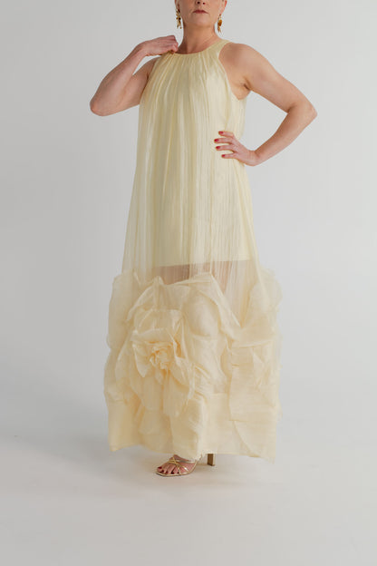 Aje Ecliptica pastel yellow sleeveless gown with high neckline, fluid shift silhouette and statement rosette hem.