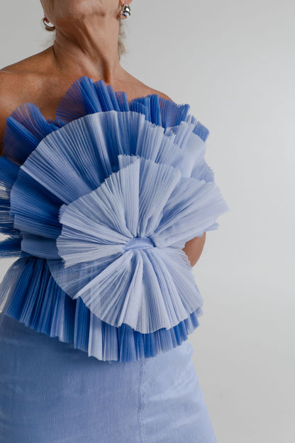 Close-up of the Aje Kira blue strapless bodice with layered sculptural pleated frills in contrasting blue tones.