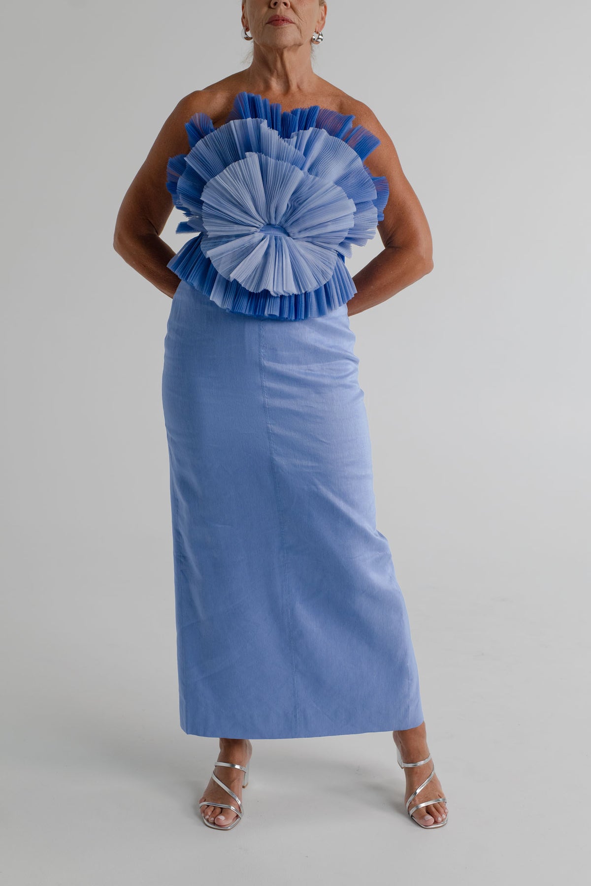Front view of the Aje Kira blue strapless midi dress showing the sculptural pleated bodice and fitted column silhouette.