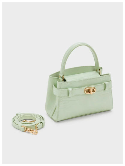 Angled side view of Charles & Keith Aubrielle mint croc-effect top handle bag with detachable strap. 