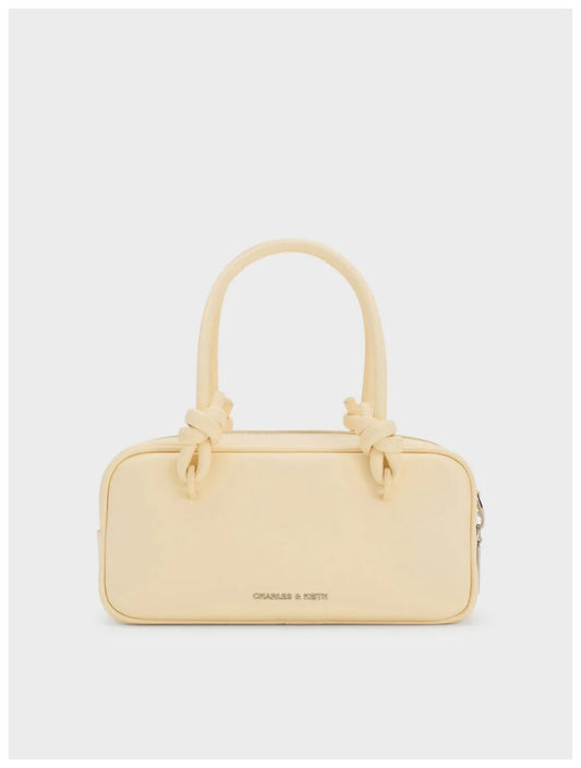 Charles & Keith Sammie pale butter yellow boxy bag with knotted top handles, front view. 
