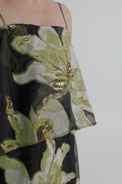 Close-up of the Elliatt Elysia Tiered Gown highlighting the sheer black fabric and textured metallic green, silver and gold floral detailing.

