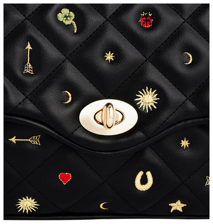 Close-up of Fable England Mary black quilted bag showing embroidered lucky motifs and gold-tone twist clasp. 
