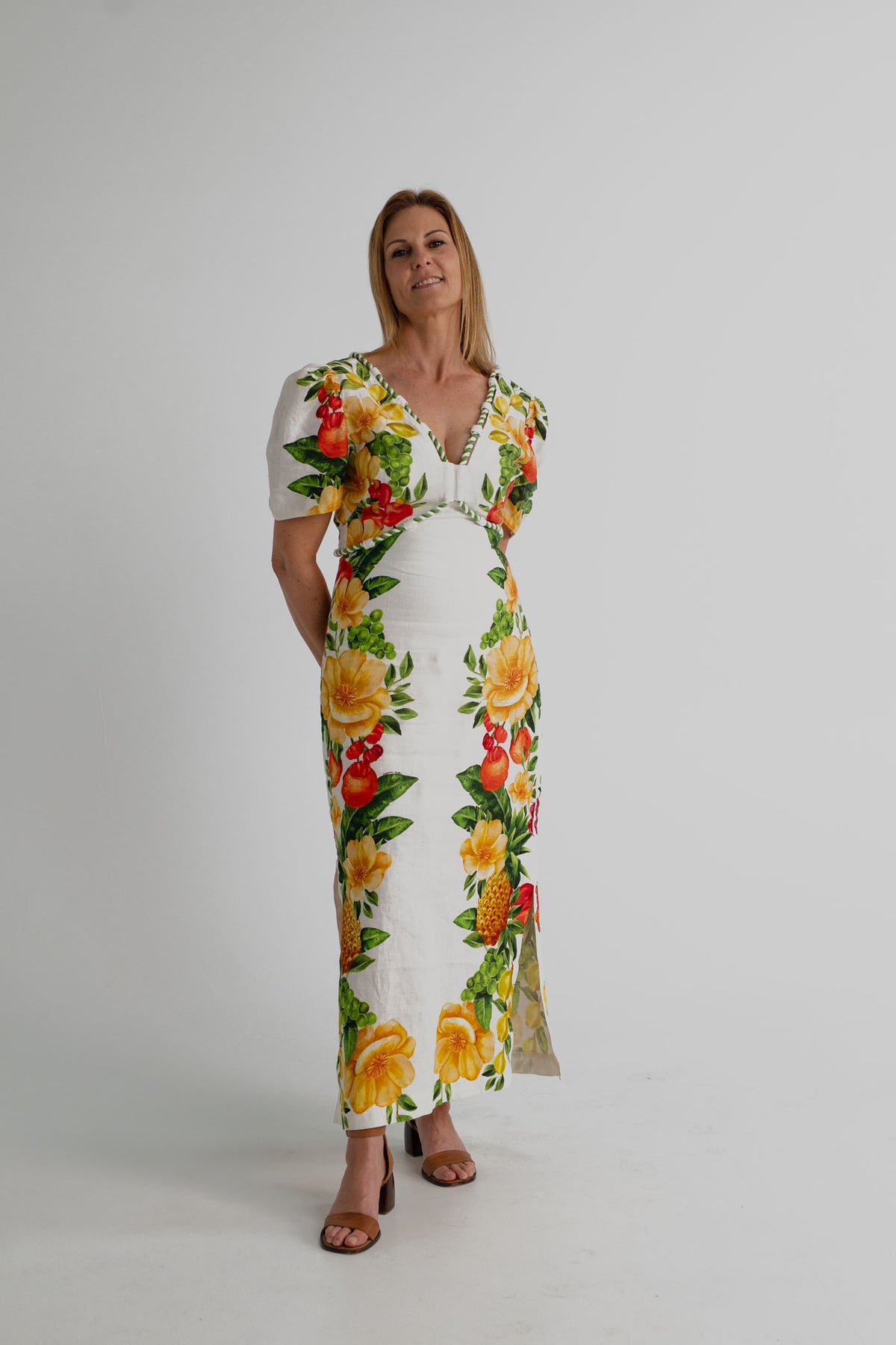 Farm Rio Picnic Flowers Off-White Maxi dress with colourful tropical fruit and floral print, puff sleeves and a deep V neckline, shown full length from the front.
