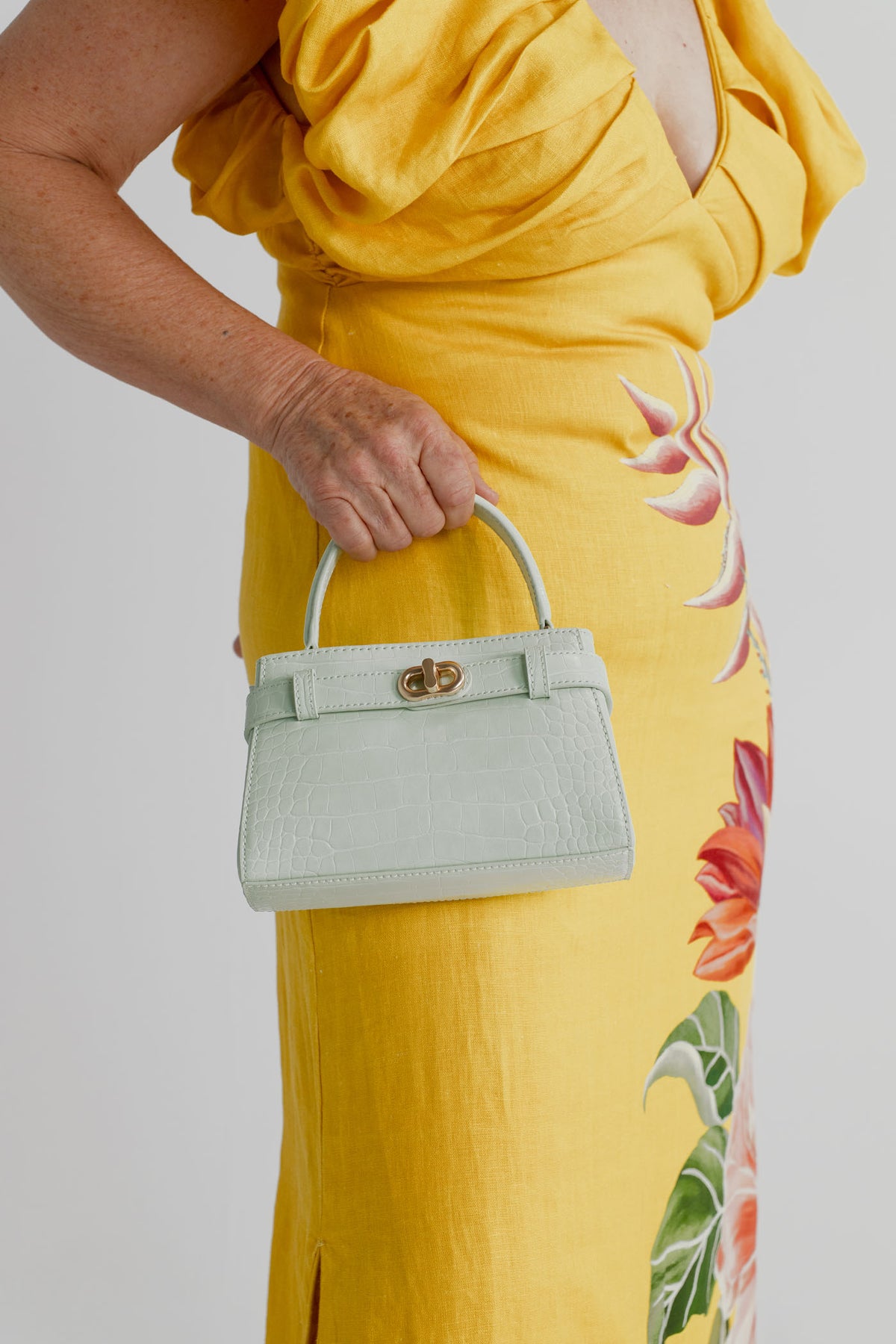 Farm Rio Spring Awakening Midi styled with the Charles & Keith Aubrielle Croc-Effect Belted Top Handle Bag in mint green.
