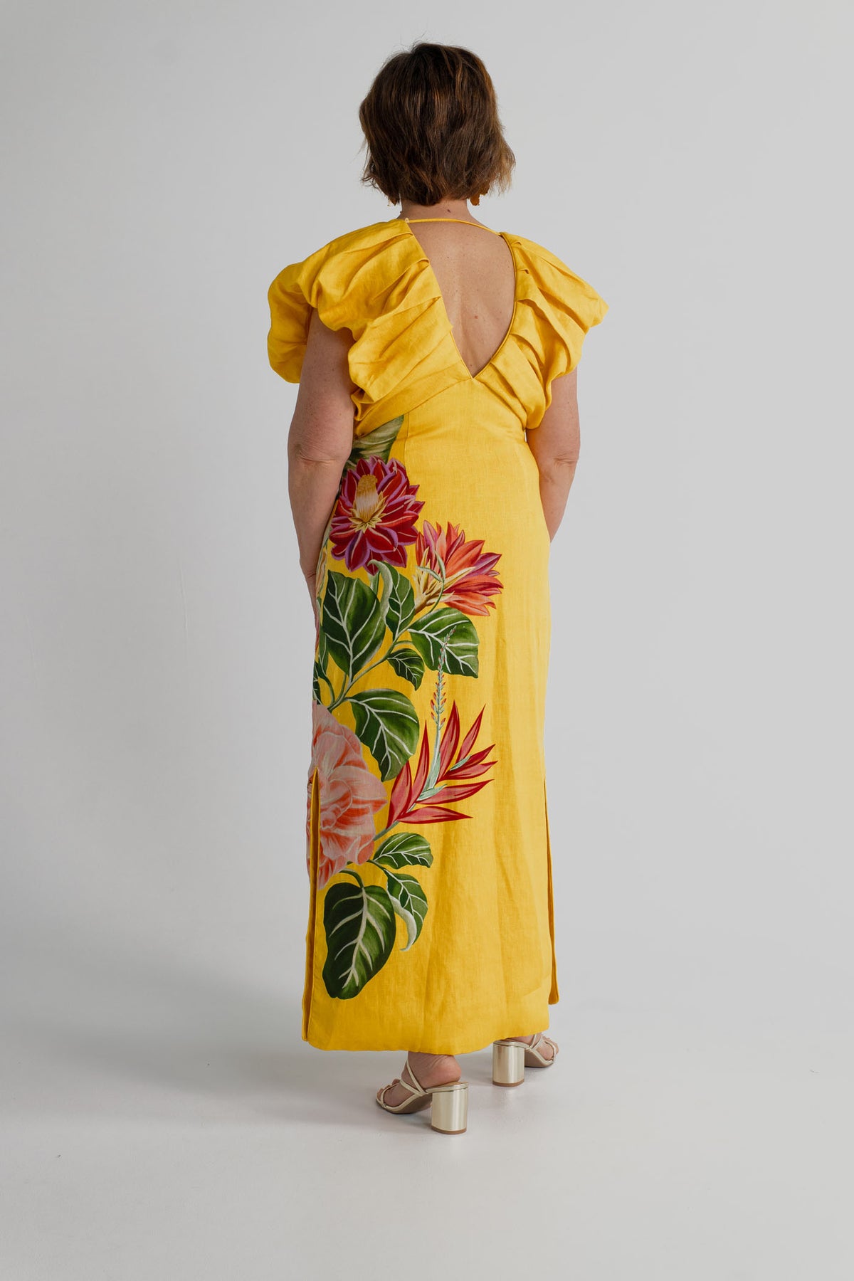 Back view of the Farm Rio Spring Awakening Midi showing the V-back, sculptural ruffle shoulders and tropical floral placement print.
