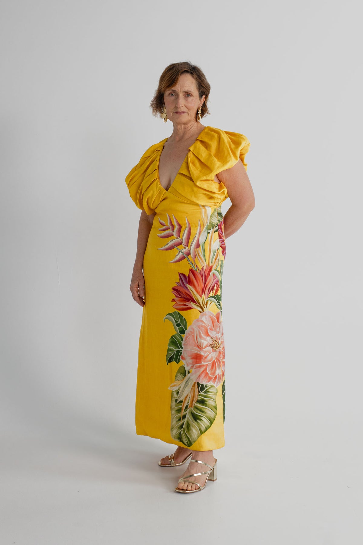Farm Rio Spring Awakening Midi dress in yellow with tropical floral placement print, deep V neckline and sculptural ruffle sleeves, shown full length from the front.
