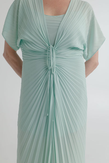 Close-up of the Georgia Hardinge Illusion mint kaftan showing the signature sunray pleating, gathered waist channel and tie detail.
