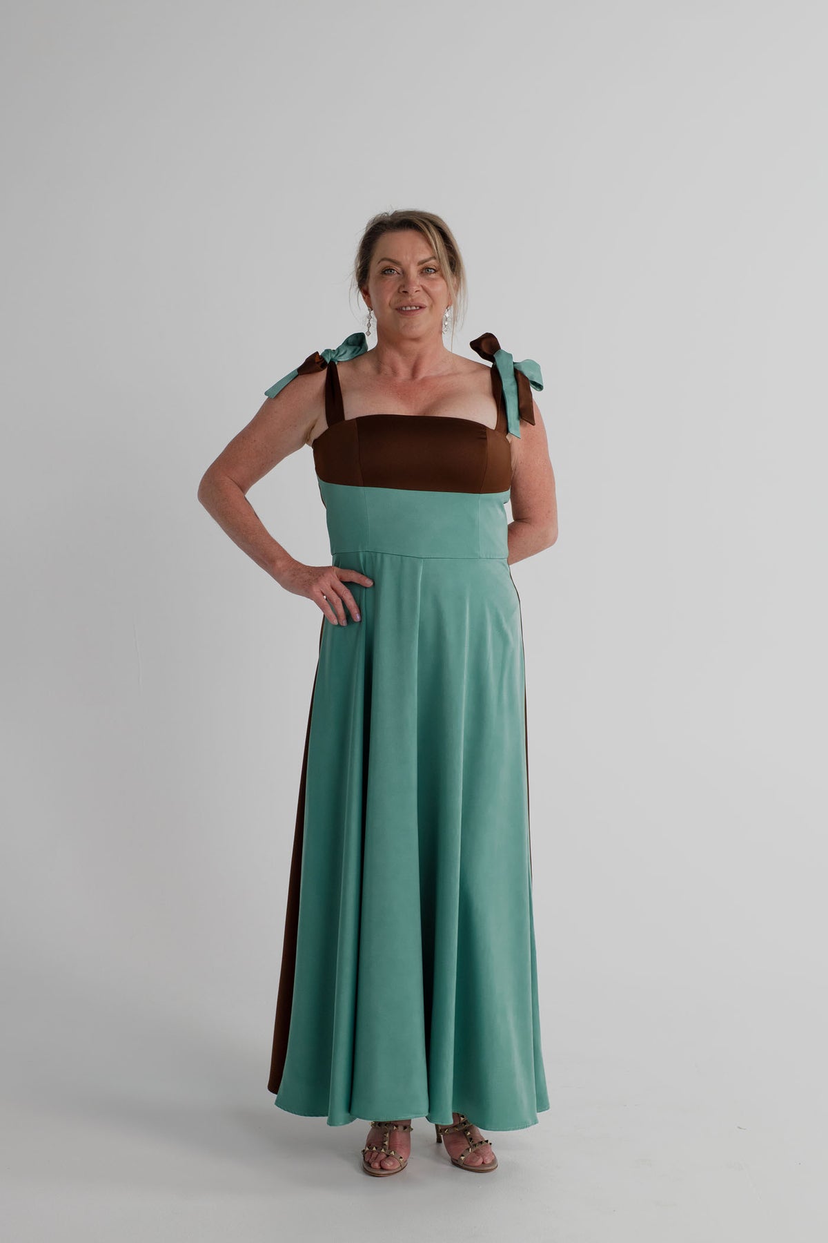 Front view of the IQ Collection Carmen Midi with aqua and chocolate colour-blocking, square neckline, bow-tie straps and full midi skirt.
