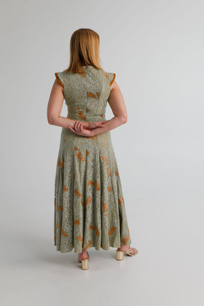 Back view of the IQ Collection Rose Maxi in sage lace, showing the fitted bodice, structured shoulders and flowing full-length skirt.
