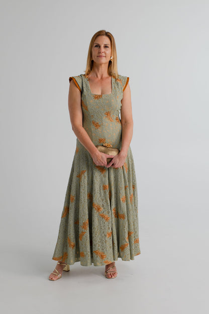 The IQ Collection Rose sage green lace maxi dress with orange floral detailing, square neckline and softly flared skirt. 
