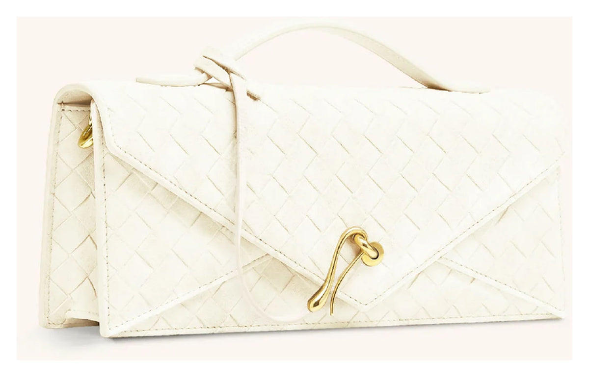 Angled side view of JW Pei Celeste ivory woven envelope top handle bag showing the structured profile and gold-tone closure. 
