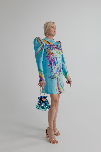 Mackenzie Mode Hollywood Blooming Mini Dress in turquoise satin with a high neckline, long puff sleeves and multicolour floral-and-stripe print, styled with the Olga Berg Pedro Sequin Pouch. 
