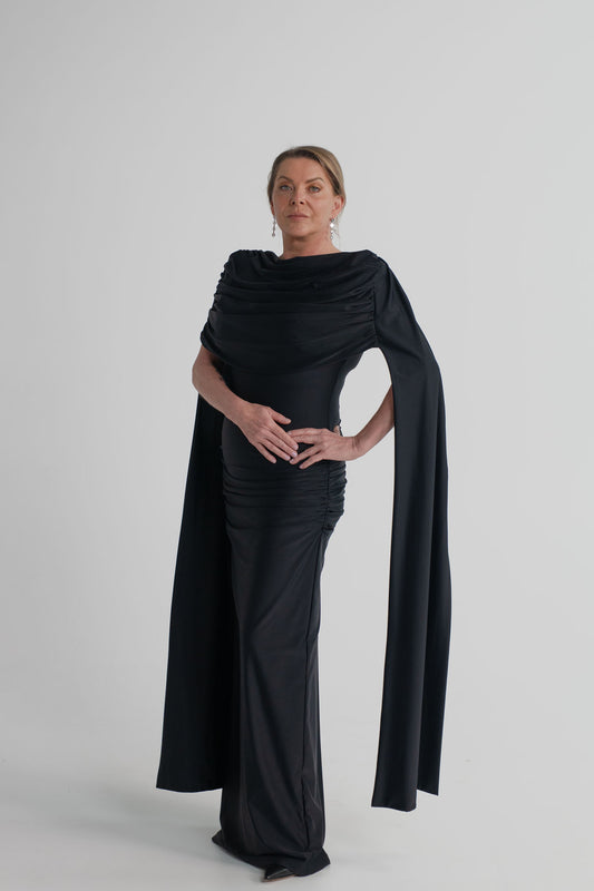 Mossman Reign black midi dress with softly draped off-shoulder neckline, dramatic cape sleeves and fitted column silhouette.
