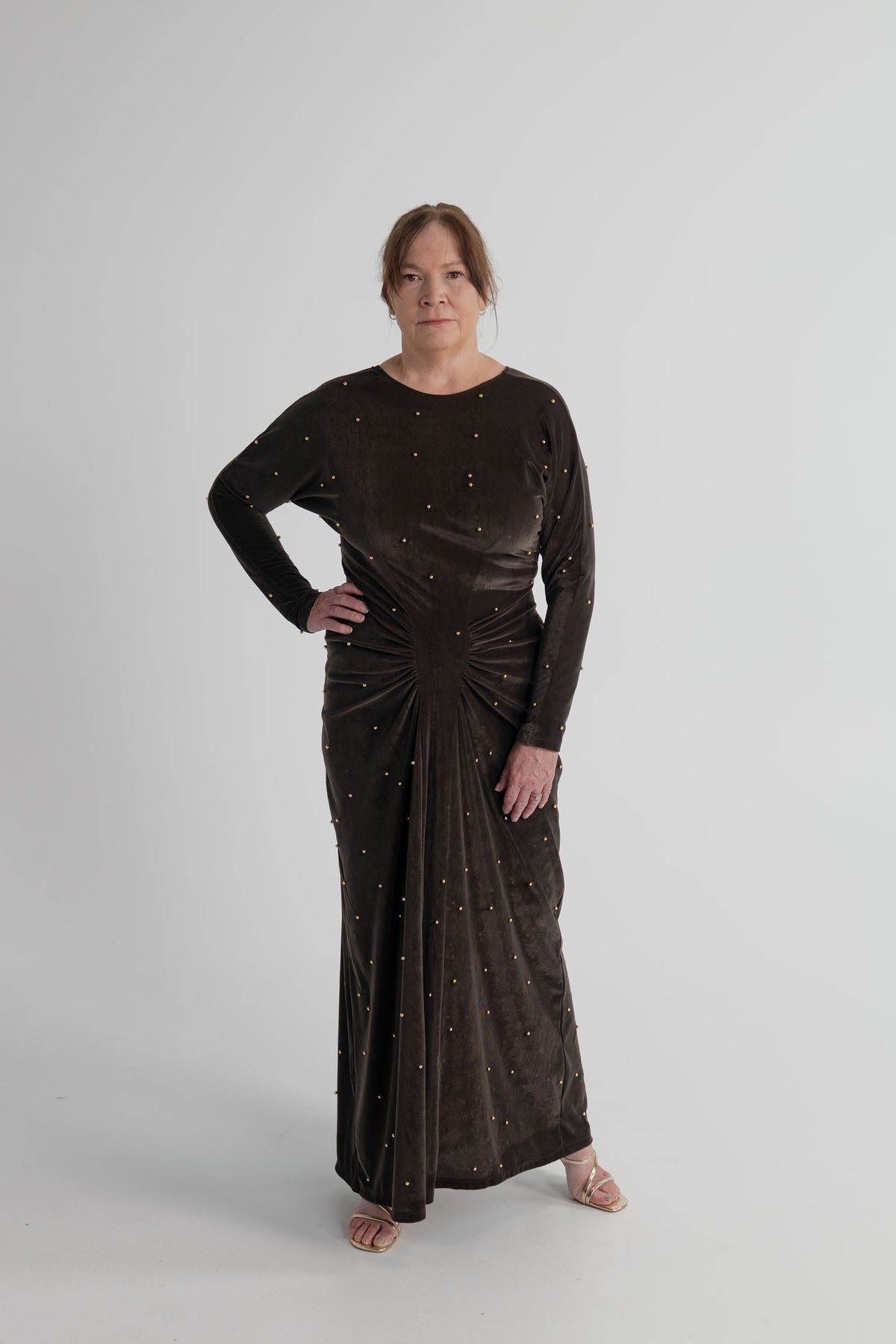 Back view of the One Fell Swoop Lucent Iron Maiden dark bronze velour maxi dress showing the V-back, long sleeves and floor-length silhouette.
