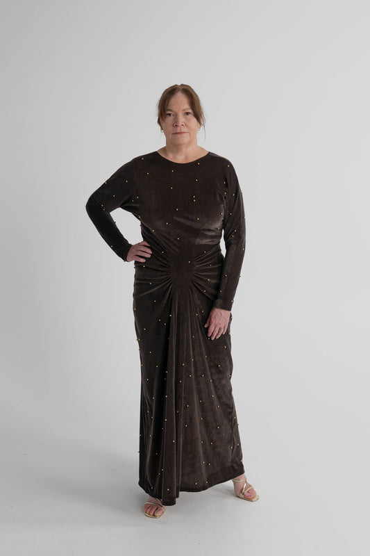Back view of the One Fell Swoop Lucent Iron Maiden dark bronze velour maxi dress showing the V-back, long sleeves and floor-length silhouette.

