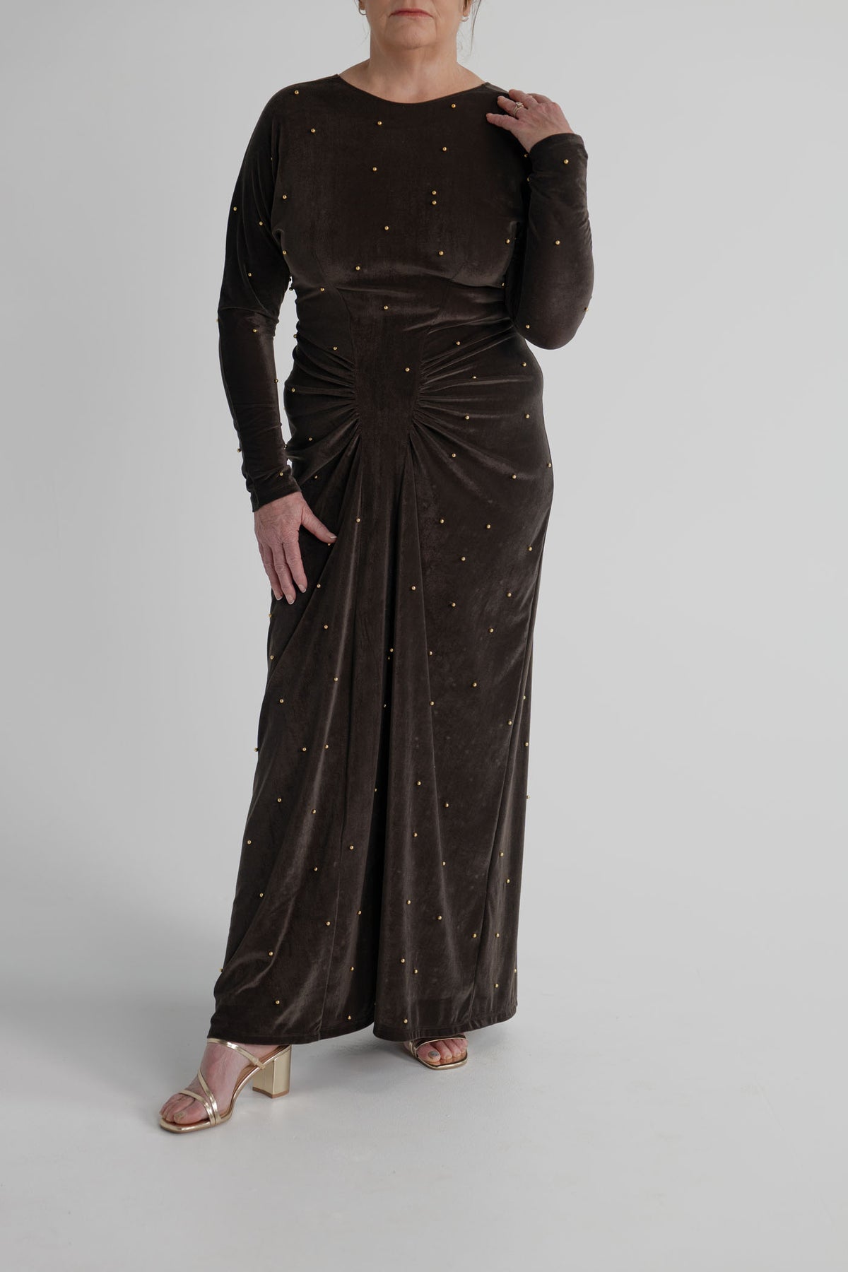 One Fell Swoop Lucent Iron Maiden dark bronze velour maxi dress with gold pearl embellishment and sculptural gathering through the waist.
