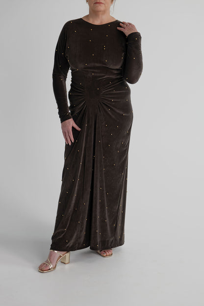 One Fell Swoop Lucent Iron Maiden dark bronze velour maxi dress with gold pearl embellishment and sculptural gathering through the waist.
