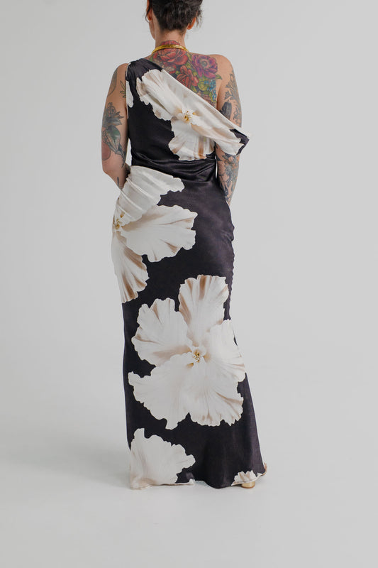 Back view of the Pasduchas Finley Midnight Bloom black and ivory floral one-shoulder satin maxi dress with fitted column silhouette.
