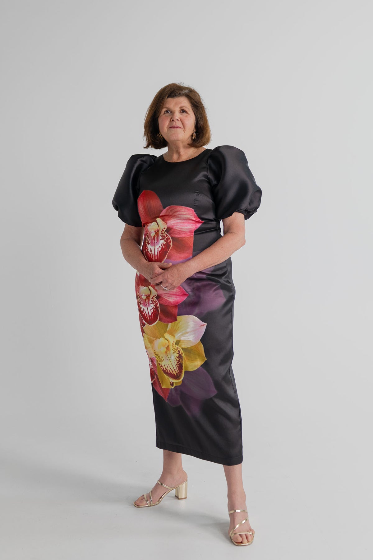 Pasduchas Nova Black Orchid midi dress with oversized floral print, sculptural puff sleeves and a fitted sheath silhouette.
