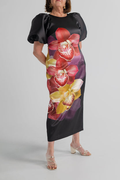 Pasduchas Nova Black Orchid midi dress with statement orchid print, short puff sleeves and streamlined fitted shape.

