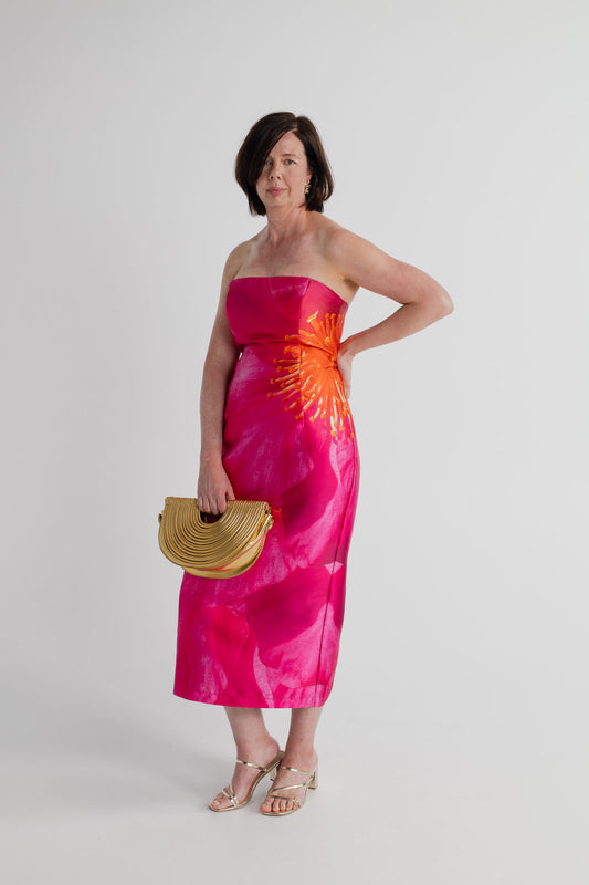 Pasduchas Thea Camellia Pink strapless midi dress styled with the Verano Hill Amara gold metallic handbag.
