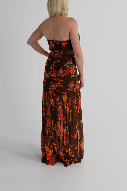 Back view of the Pasduchas Wren chocolate floral strapless maxi dress showing the gathered fitted bodice and flowing full-length skirt.
