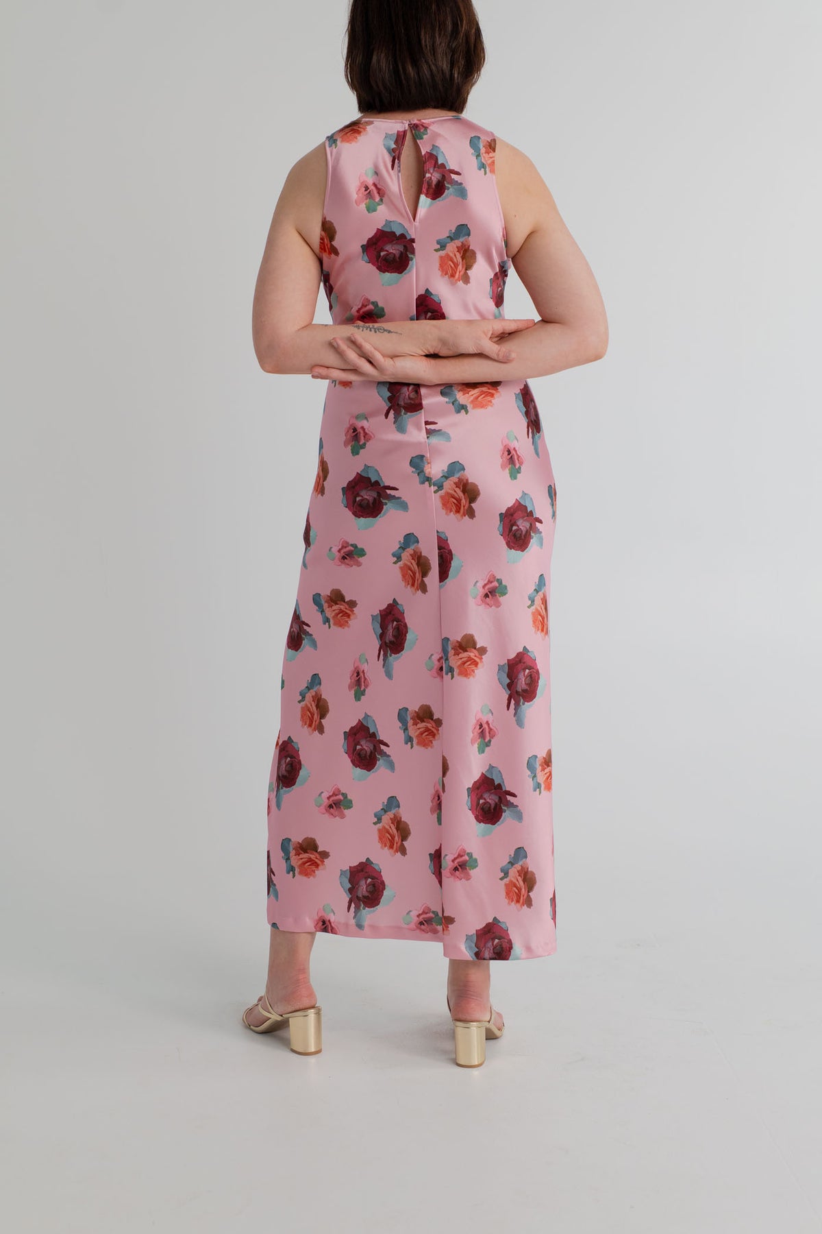 SABA Bettina Maxi Dress in pink satin with scattered floral print, sleeveless high neckline, fitted column silhouette and thigh-high side split. 
