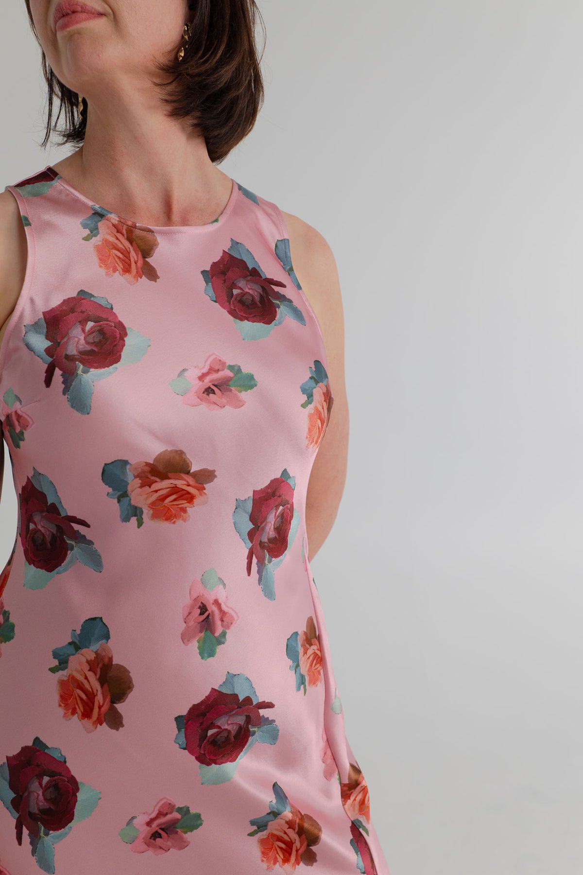 Close-up of the SABA Bettina Maxi Dress showing the soft pink satin, multicolour rose print and clean sleeveless neckline. 
