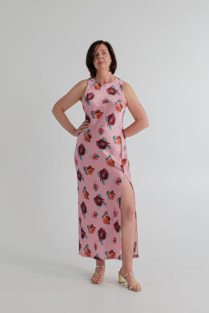 SABA Bettina Maxi Dress in pink satin with scattered floral print, sleeveless high neckline, fitted column silhouette and thigh-high side split. 
