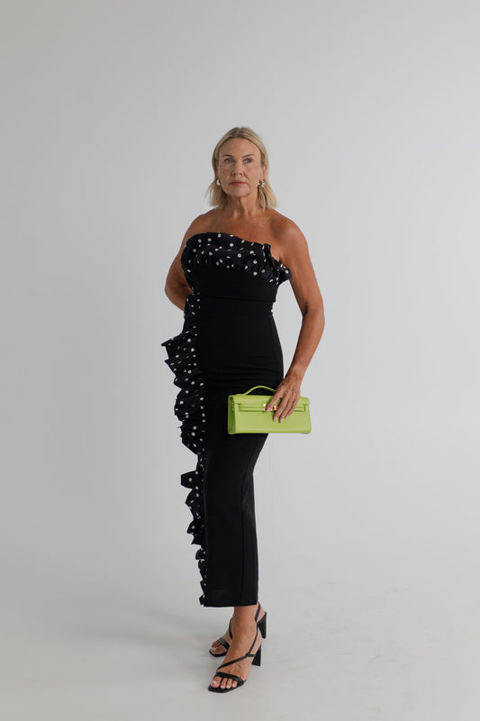 Sonya Moda Palermo Dress styled with the Bria Structured Top Handle Bag in bright green, showing the strapless black dress and cascading polka-dot ruffle. 
