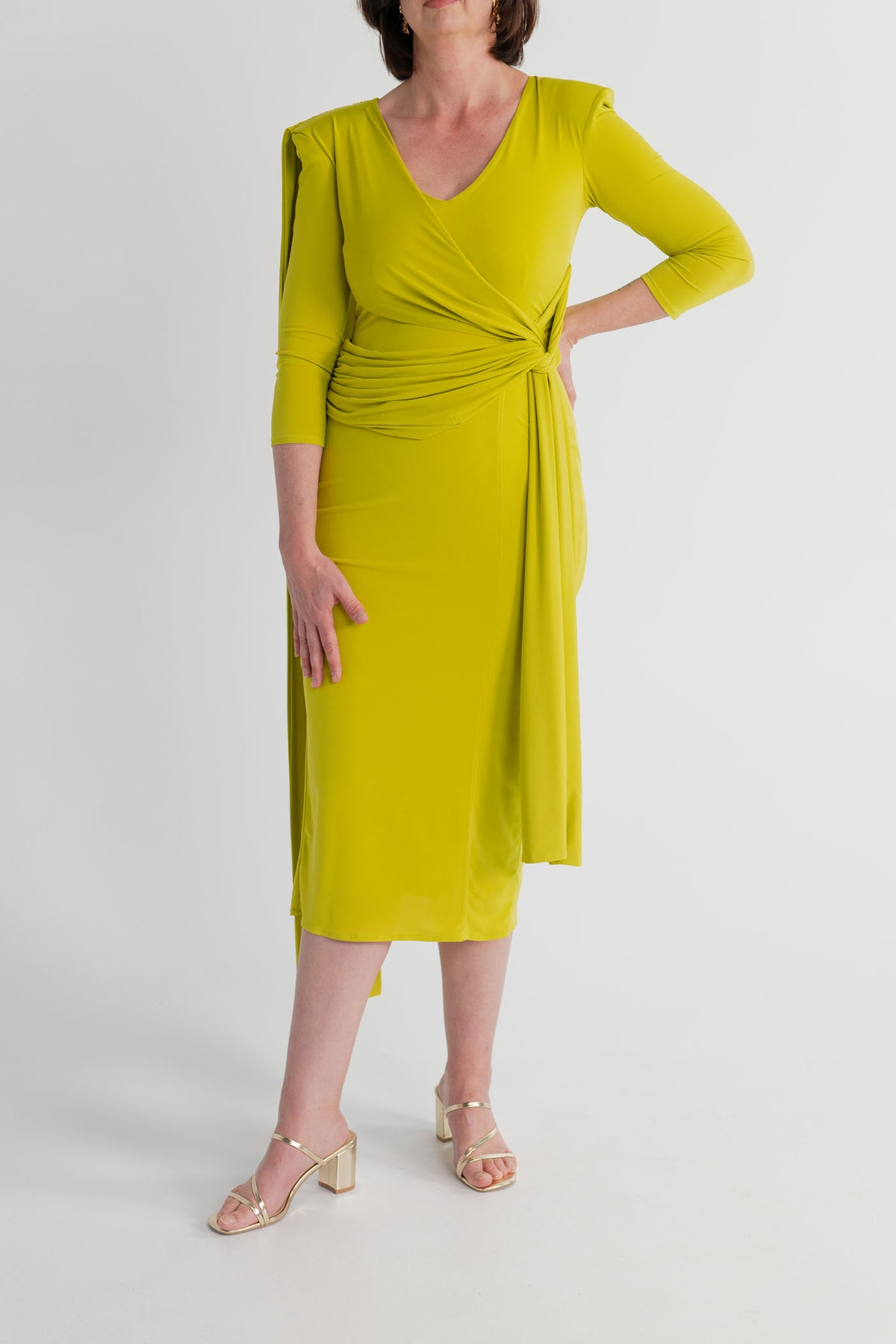 Front detail of the Strena Barbara Midi Dress in chartreuse showing the V neckline, three-quarter sleeves and gathered wrap-style waist.
