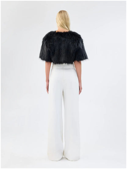 Back view of Unreal Fur Love a Fur black faux fur bolero showing the cropped length, plush texture and short sleeves. 
