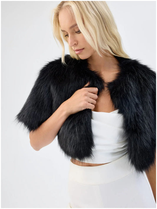 Close front view of Unreal Fur Love a Fur black faux fur bolero showing the plush texture, open front and cropped silhouette. 
