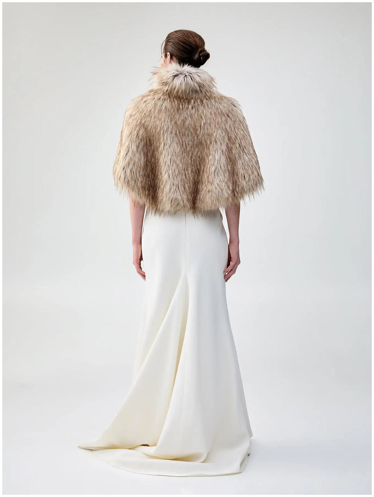 Back view of Unreal Fur Nord Cape in natural showing the cropped cape silhouette, high collar and long-pile faux fur texture. 
