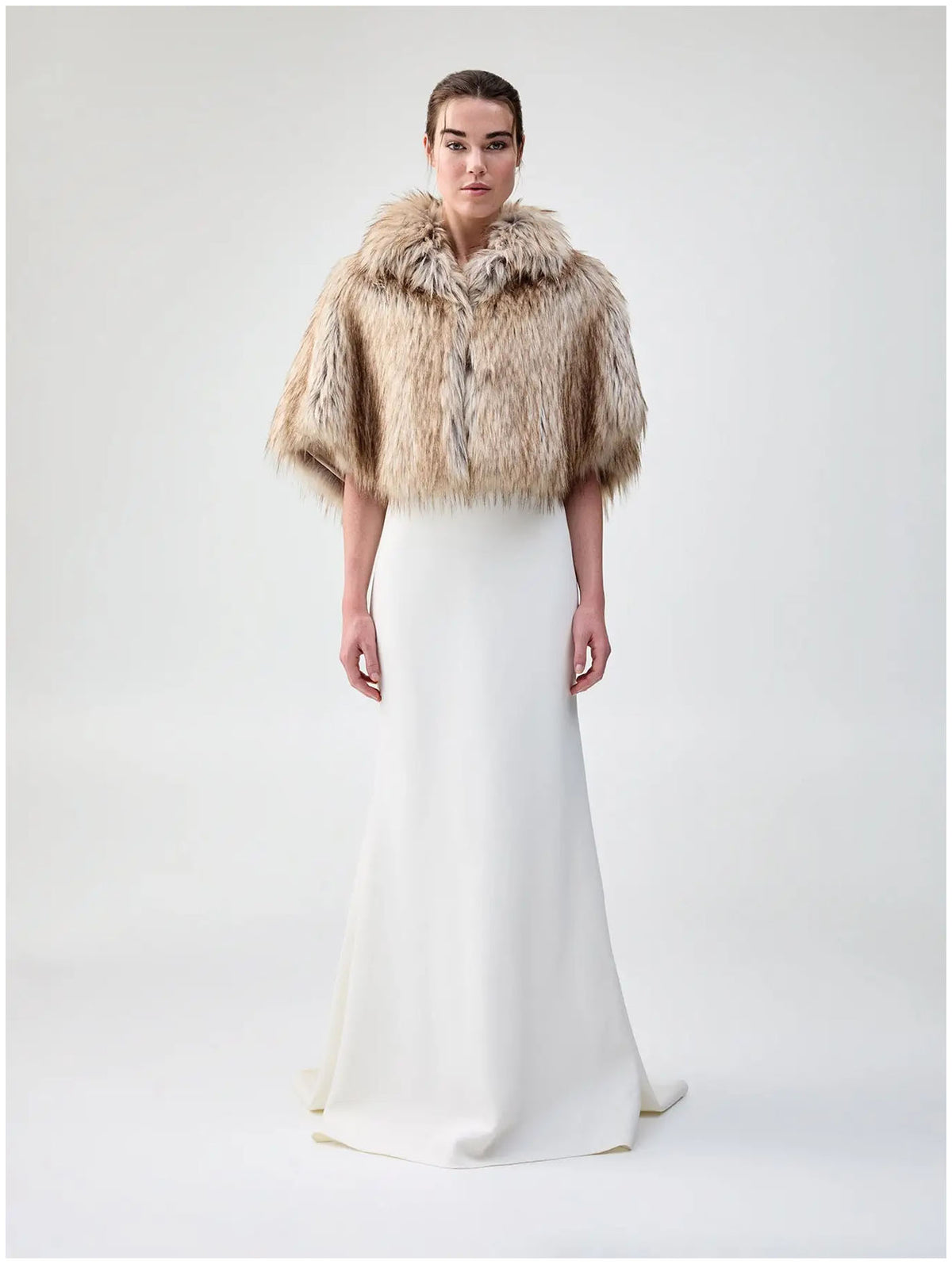Front view of Unreal Fur Nord Cape in natural showing the cropped cape silhouette, high collar and soft long-pile faux fur finish. 
