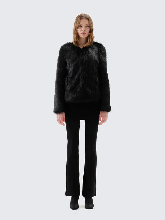Back view of Unreal Fur Unreal Dream black faux fur jacket showing the straight hip-length silhouette, long sleeves and smooth plush texture. 
