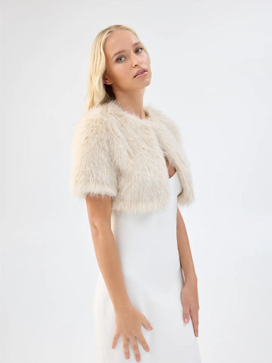 Side view of Unreal Fur Wings Bolero in caramel showing the cropped length, short sleeves and soft faux fur texture. 
