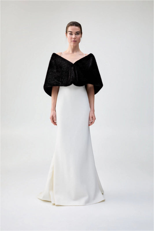 Front view of Unreal Fur Yasmine Wrap in black faux fur styled over a white gown. 
