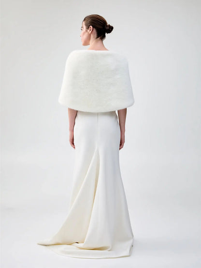 Back view of Unreal Fur Yasmine Wrap in white faux fur styled over a white gown. 
