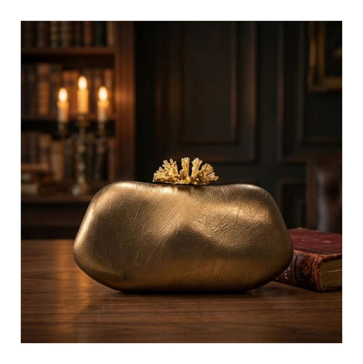 Verano Hill Coraline bronze sculpted bag with metallic finish and coral-inspired gold-tone clasp, styled in a dark interior. 
